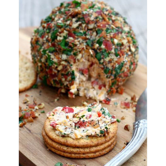 A savory cheese ball topped with crispy bacon and fragrant herbs, displayed on a wooden cutting board.