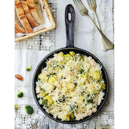 Skillet with Chicken Broccoli and Rice and plate of bread. Stovetop cooking, easy prep, keeps your kitchen cool.