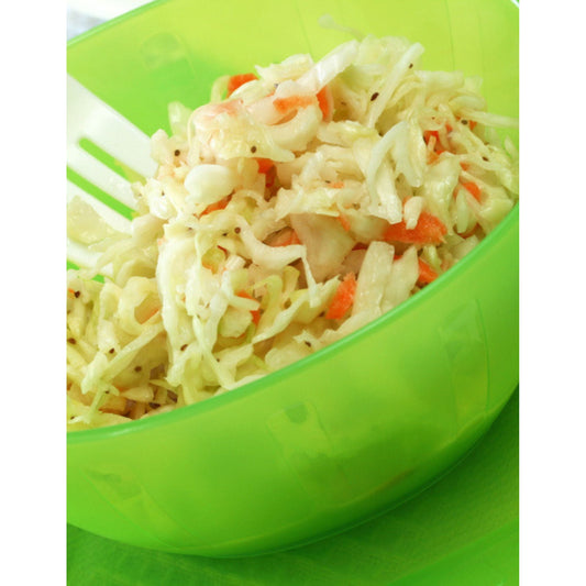 A green bowl with a fork in it, containing Cole Slaw seasoning mix for a perfect barbeque or fish dinner.