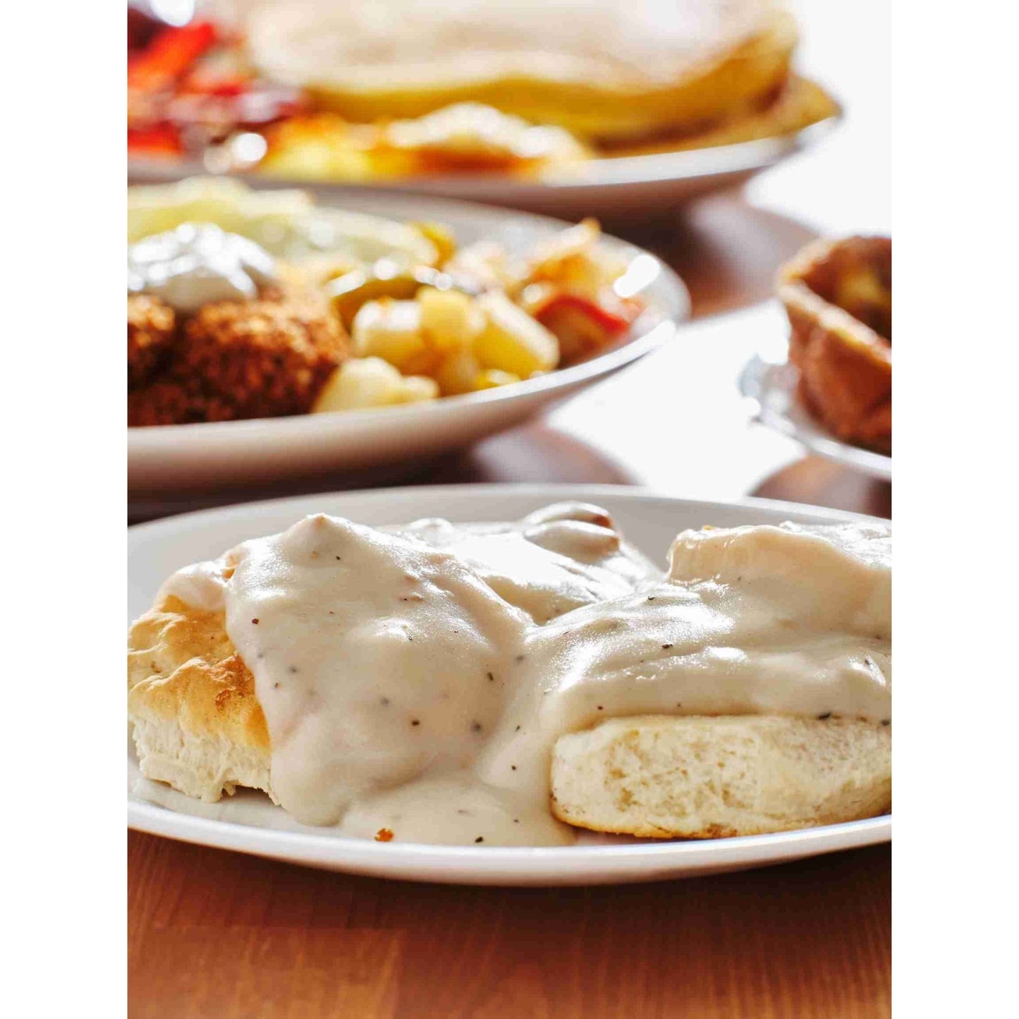 A plate of biscuits and gravy with a bowl of savory breakfast gravy. Also known as Sawmill gravy, white gravy, or pepper gravy. Country Gravy Seasoning 