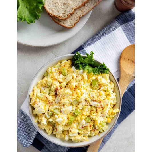 A bowl filled with egg salad, featuring chopped hard-boiled eggs mixed with mayonnaise and our seasonings.