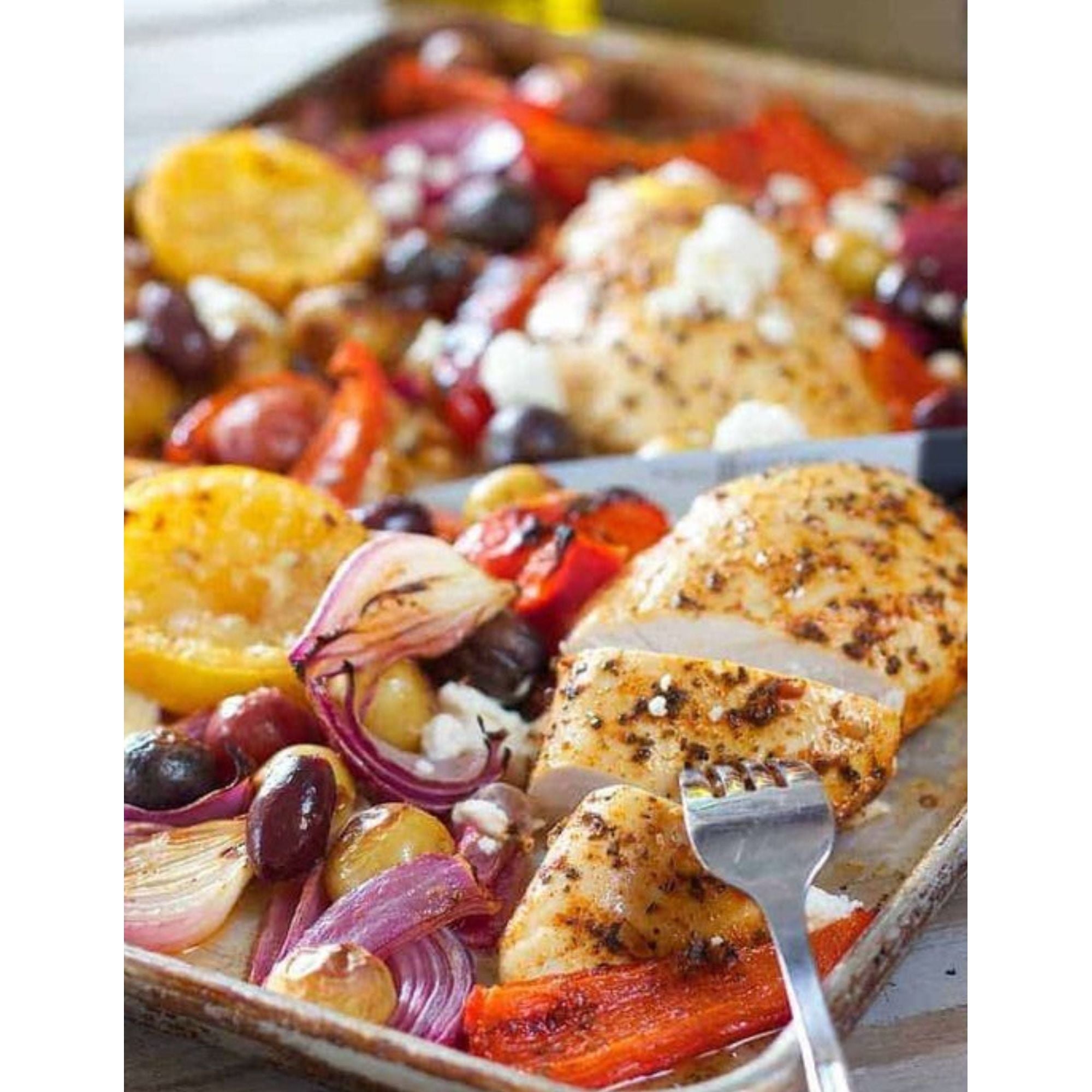 Greek sheet pan meal with chicken, feta cheese, peppers and olives.
