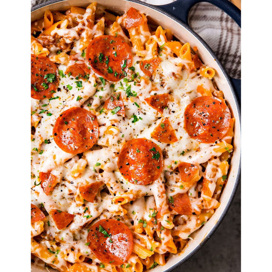 A mouthwatering pepperoni pizza pasta in a pan, topped with gooey cheese and savory pepperoni slices.