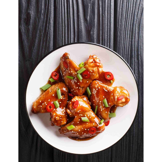 Teriyaki Chicken wings and sesame seeds on a white plate.