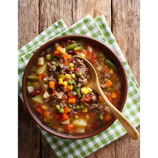 A bowl of hearty beef and vegetable soup, garnished with a wooden spoon for a comforting meal.